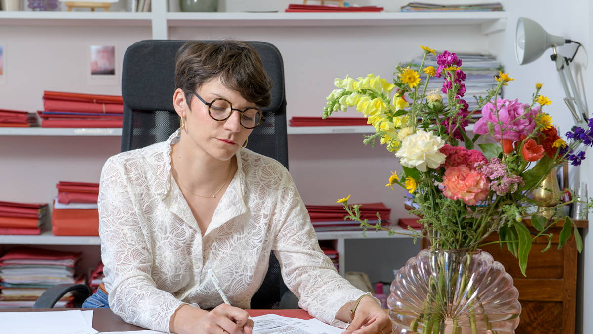 Charlotte Bonnaire travaillant sur un dossier dans son cabinet